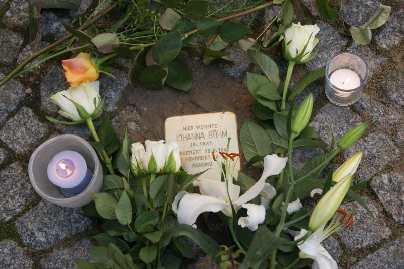 Stein mit Blumen und Kerzen