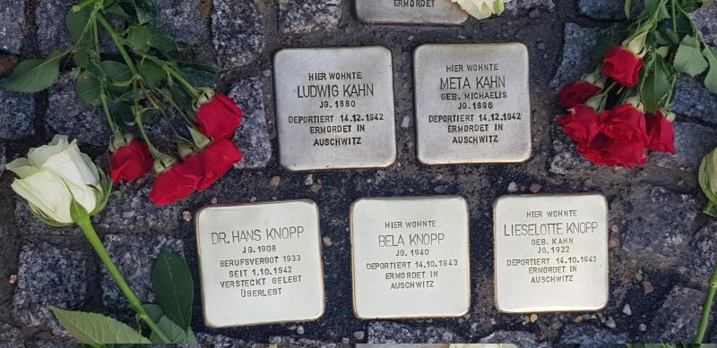 Das Foto zeigt drei Stolpersteine für die Fam. Knopp, sowie zwei ältere des Ehepaares Kahn mit Blumen von der Verlegung.