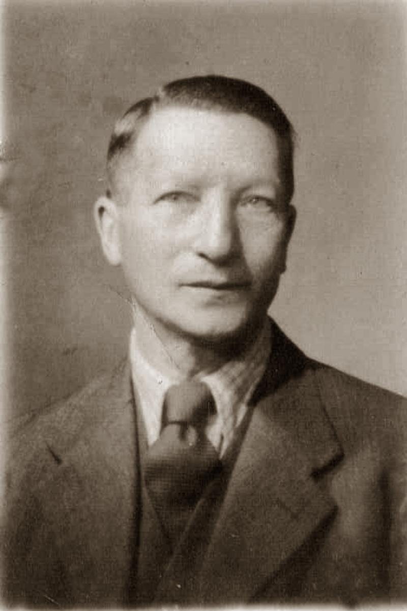 Passfoto Josef David Wolf, frontal. Josef trägt Anzug, weißes Hemd und Krawatte