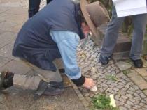 Gunter Demnig reinigt den früher verlegten Stein